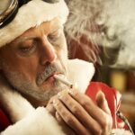 Man in Santa Clause Suite Smoking Joint - Last Minute Cannabis Gifts Hero Image