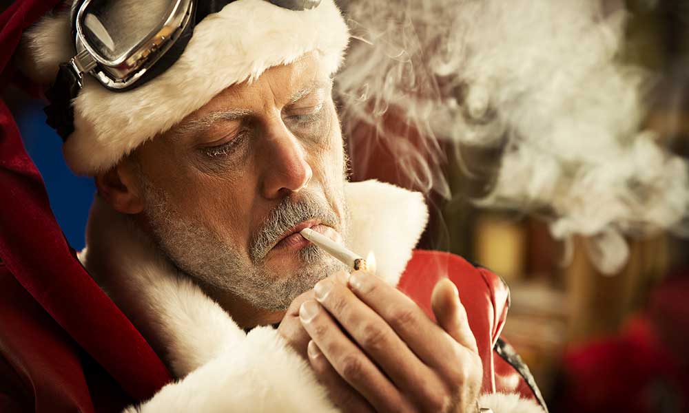 Man in Santa Clause Suite Smoking Joint - Last Minute Cannabis Gifts Hero Image